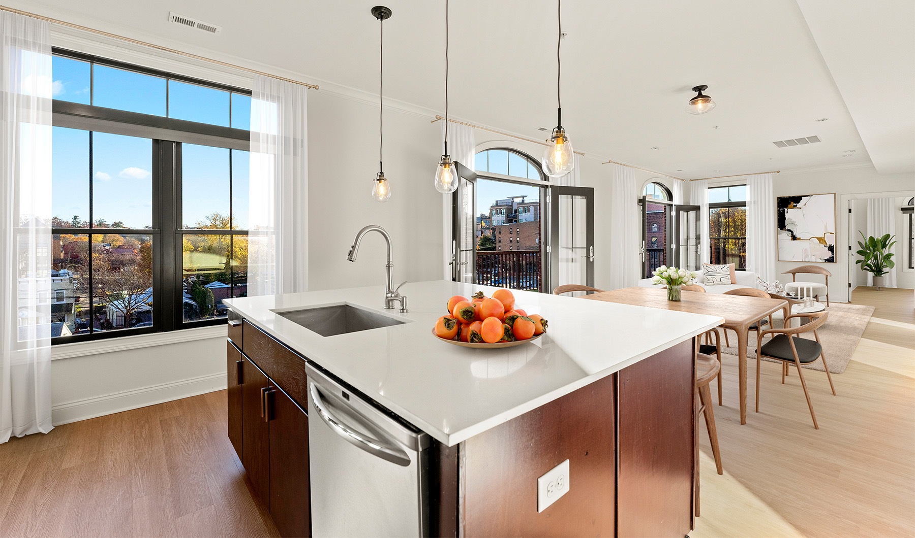 a kitchen island in a room with tall windows